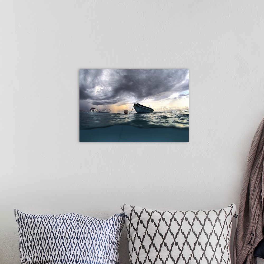 A bohemian room featuring View from the surface of the ocean of a boat at sea with dark clouds in the sky.
