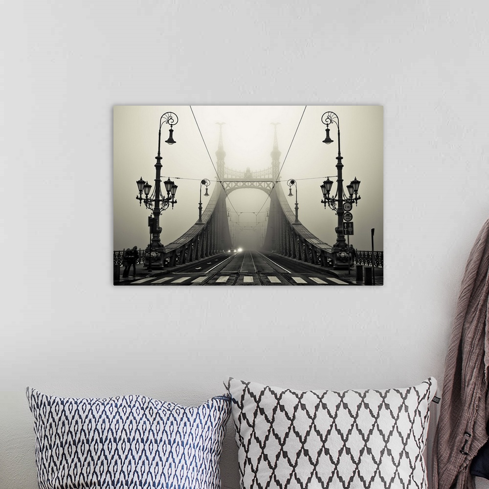 A bohemian room featuring Ornate iron street lamps stand at the entrance to a bridge in Budapest, Hungary.
