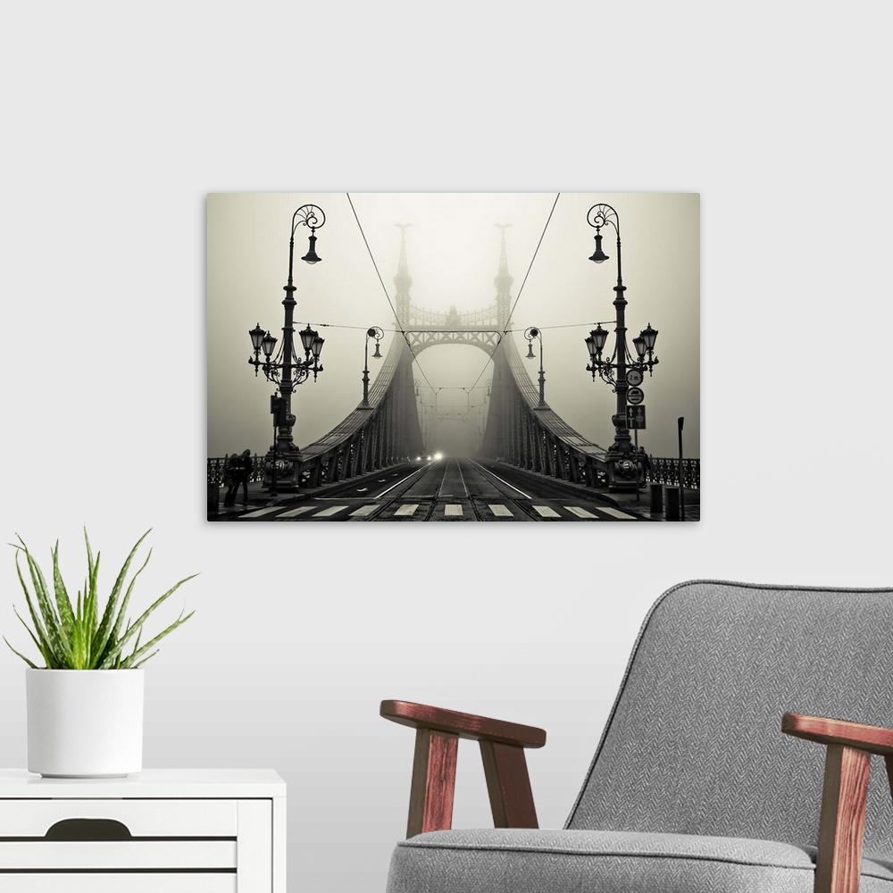 A modern room featuring Ornate iron street lamps stand at the entrance to a bridge in Budapest, Hungary.