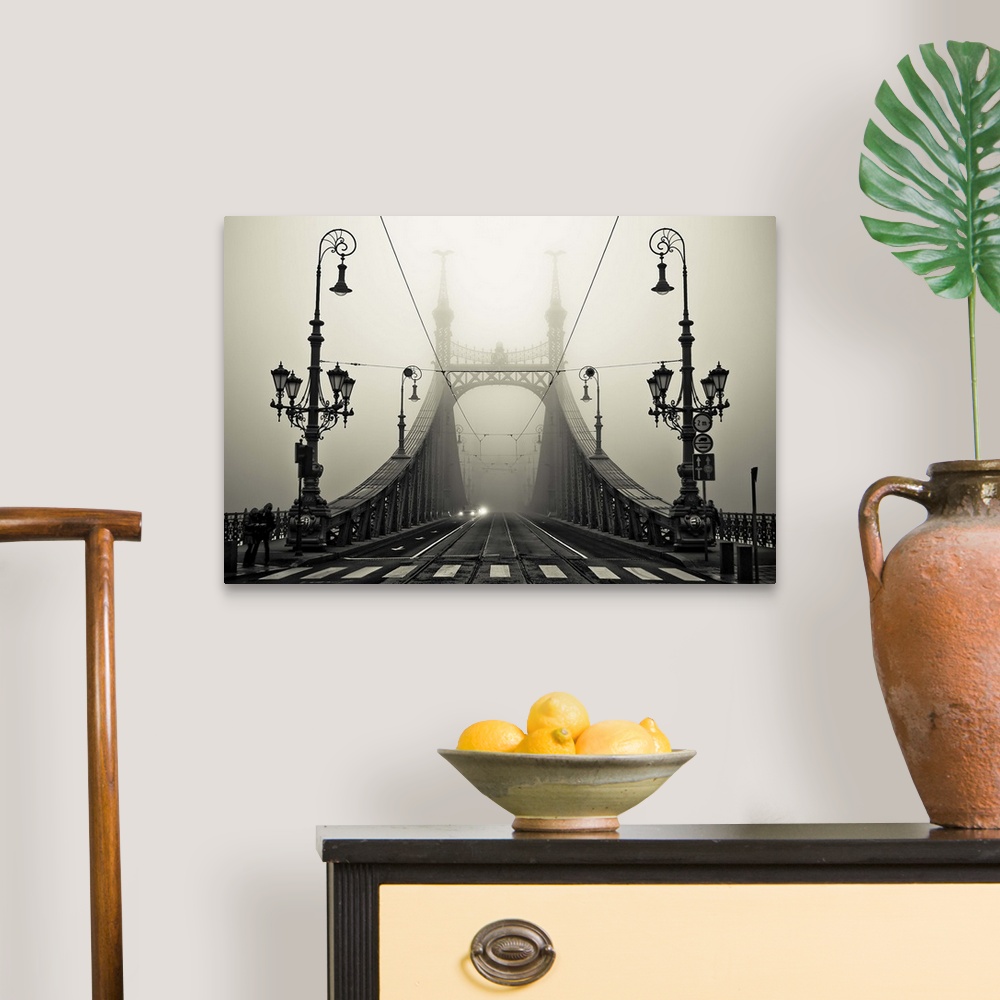A traditional room featuring Ornate iron street lamps stand at the entrance to a bridge in Budapest, Hungary.