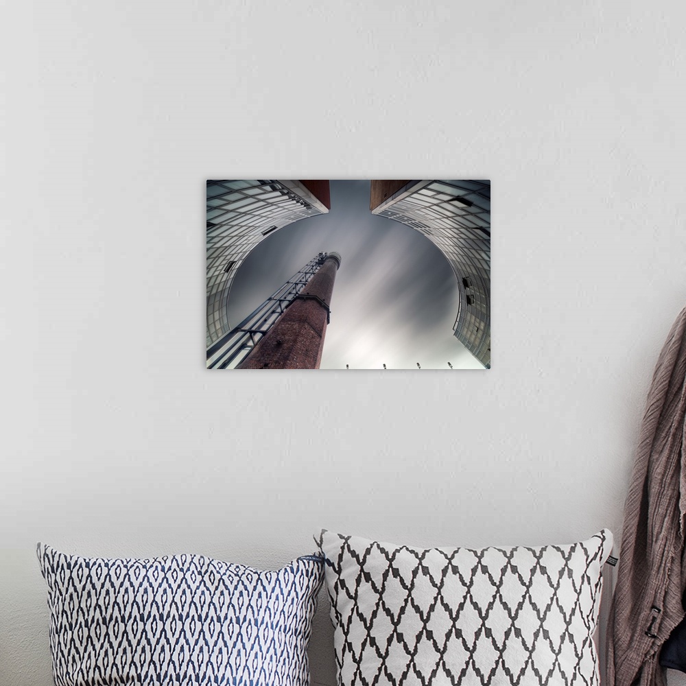 A bohemian room featuring Abstract view of a chimney in a factory framed by curved buildings.