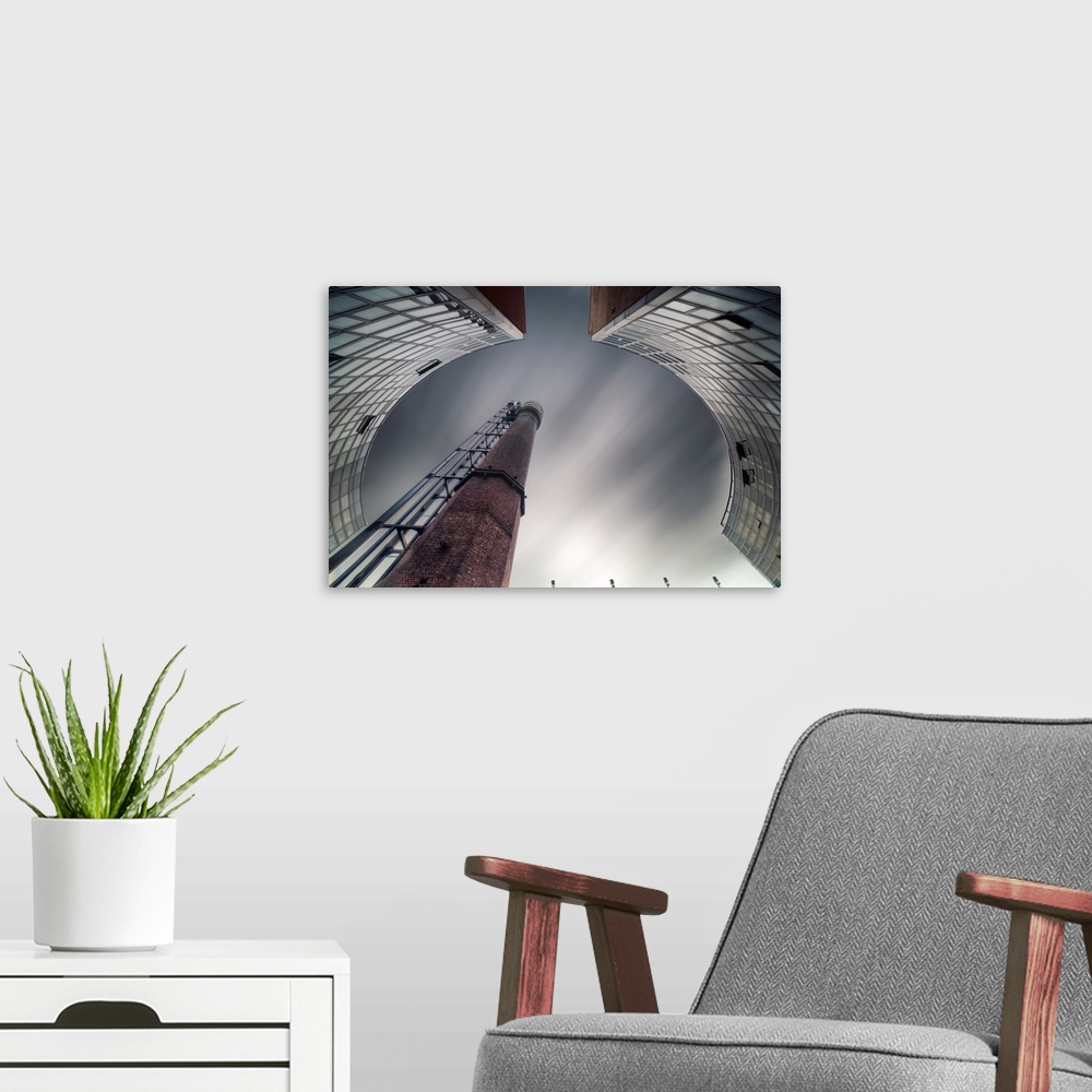 A modern room featuring Abstract view of a chimney in a factory framed by curved buildings.