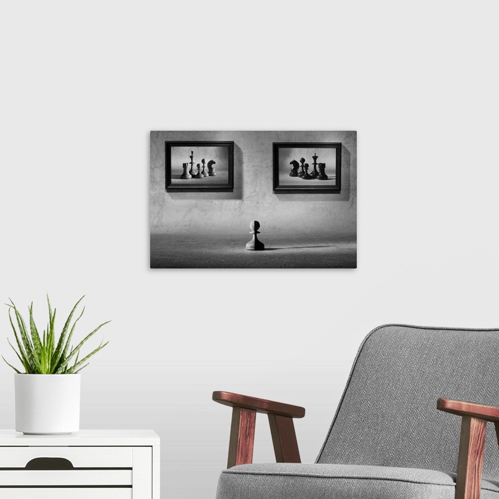 A modern room featuring A chess pawn, half black, half white, sitting under two framed images of chess pieces of opposing...