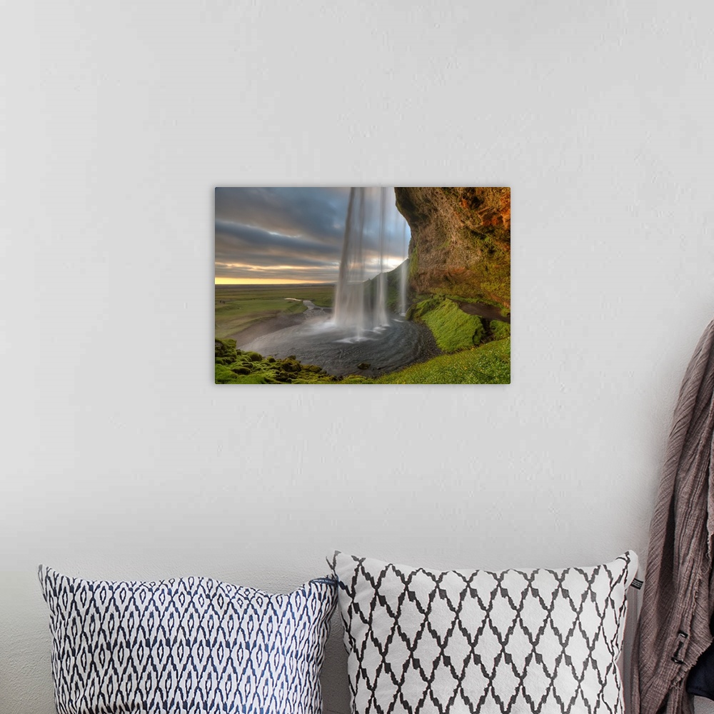 A bohemian room featuring The Seljalandsfoss Waterfall in Iceland and the wide open landscape in the distance.