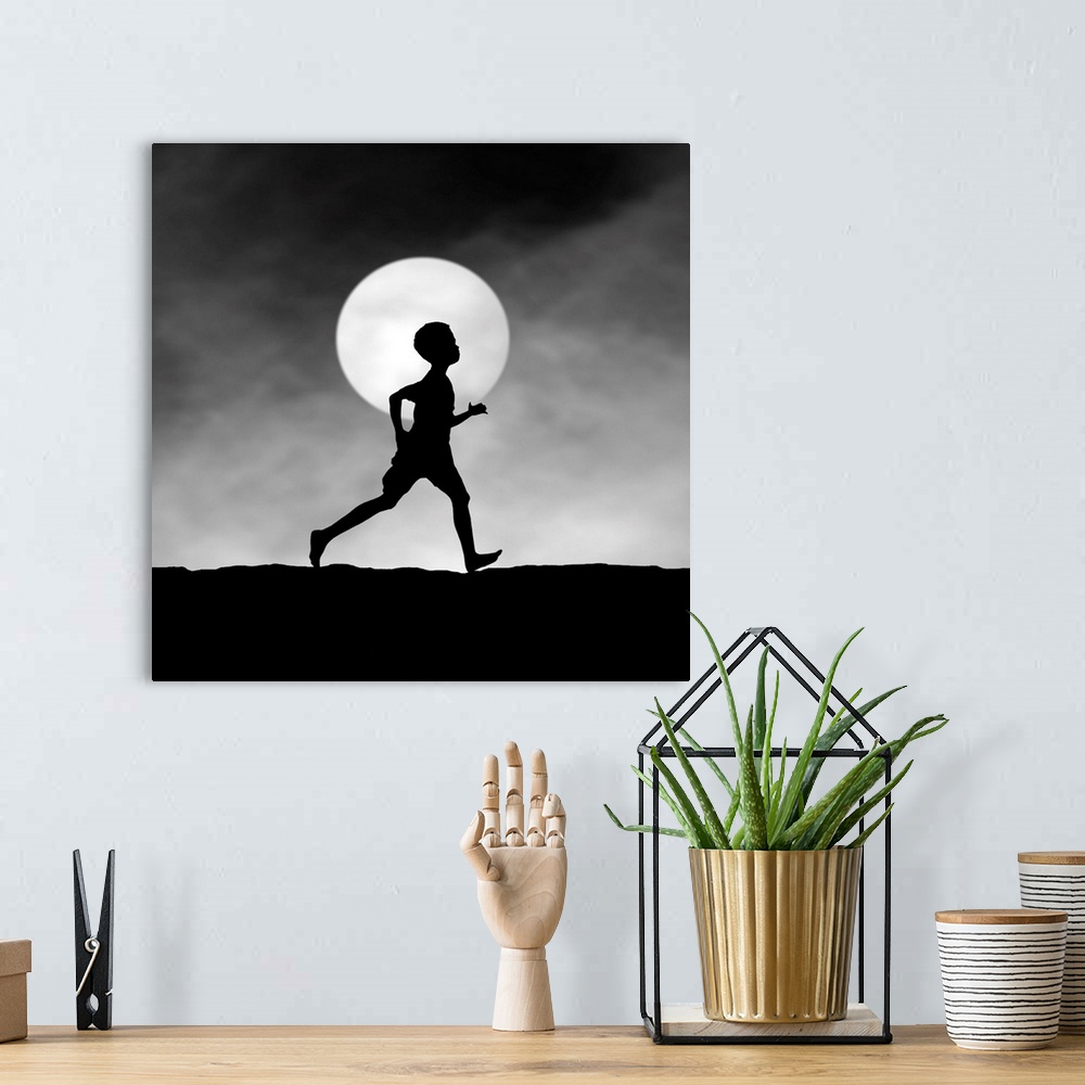 A bohemian room featuring Silhouette of a boy running at night, in front of the full moon.