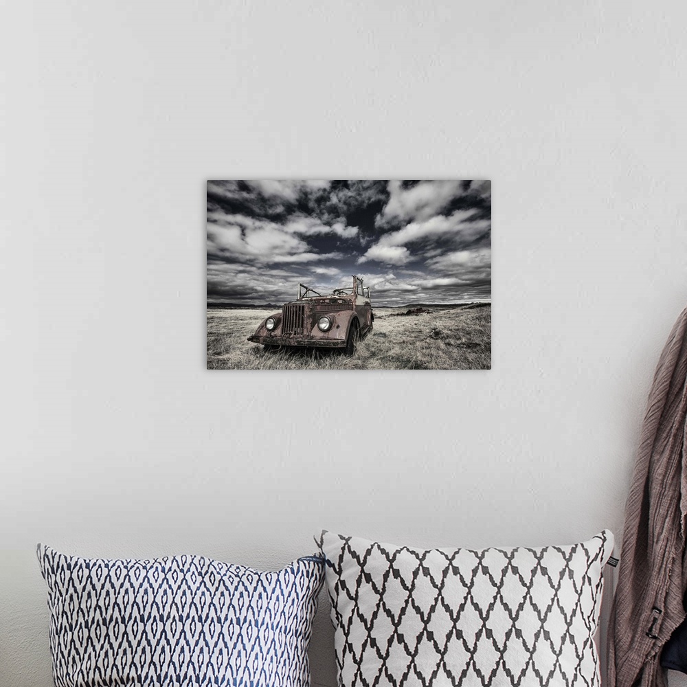 A bohemian room featuring A rusted, abandoned truck in a field in Iceland, under a cloudy sky.