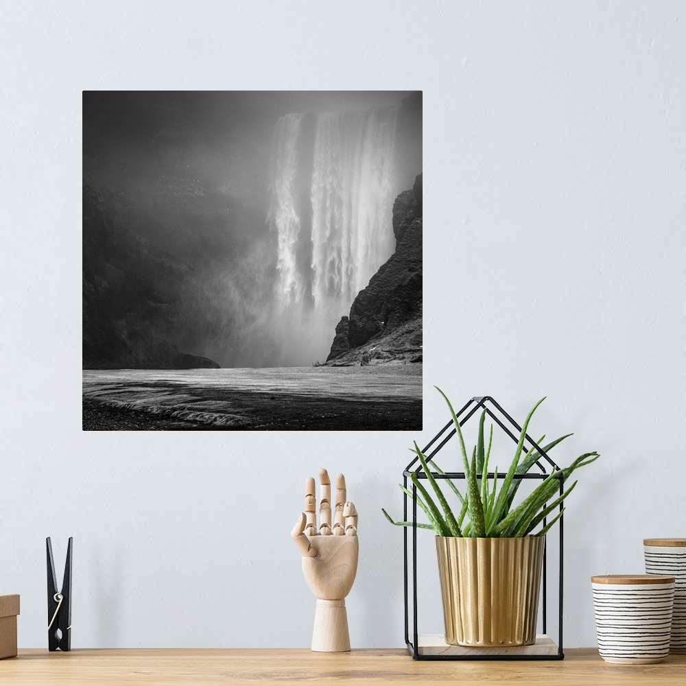 A bohemian room featuring A massive curtain of water falls down onto a rocky surface