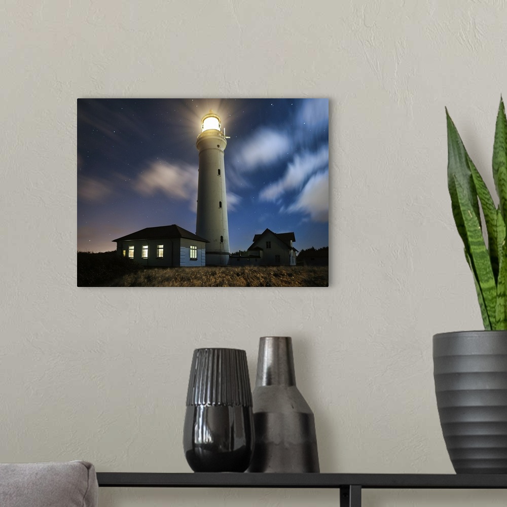 A modern room featuring A lighthouse shining on the coast on a starry night.