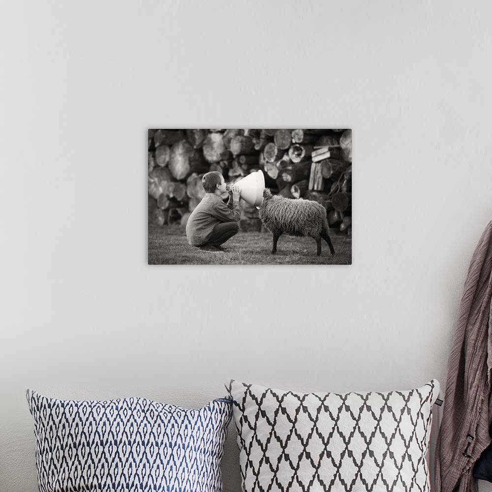 A bohemian room featuring A black and white photograph of a child talking into funnel with a sheep poking its head into the...