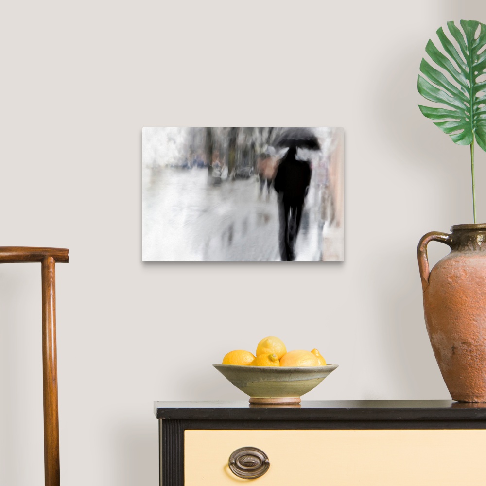 A traditional room featuring Blurred image of a figure with an umbrella walking in the rain.