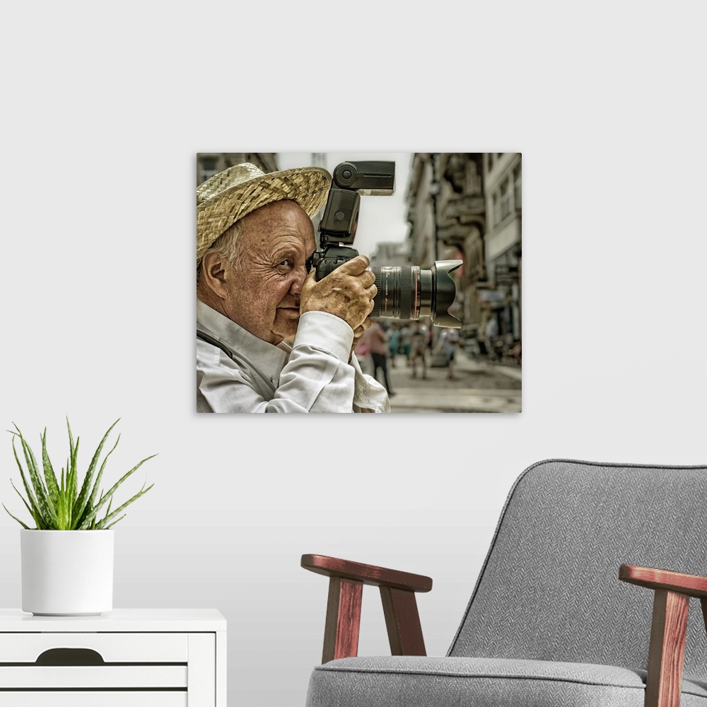 A modern room featuring Portrait of an elderly man taking a photo with a large camera, Budapest, Hungary.
