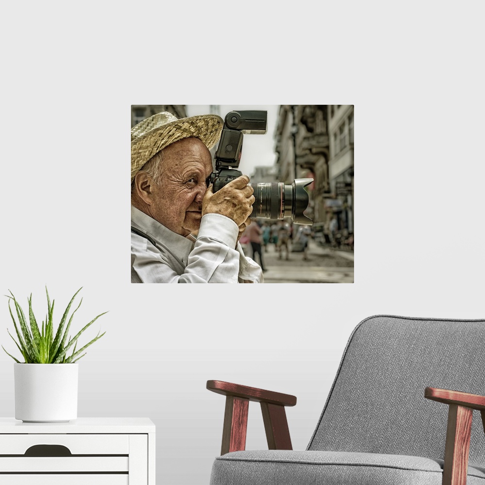 A modern room featuring Portrait of an elderly man taking a photo with a large camera, Budapest, Hungary.