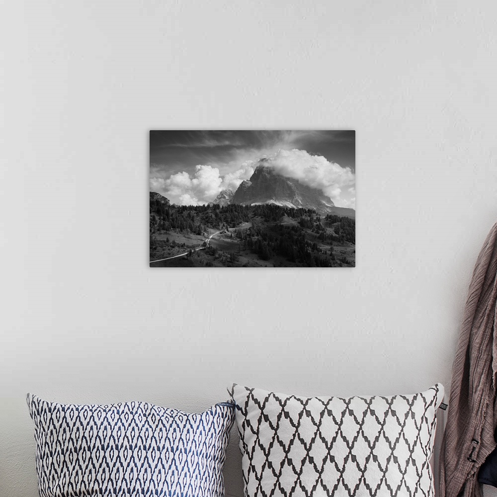 A bohemian room featuring A giant cloud passes over a mountaintop, resembling billowing smoke.