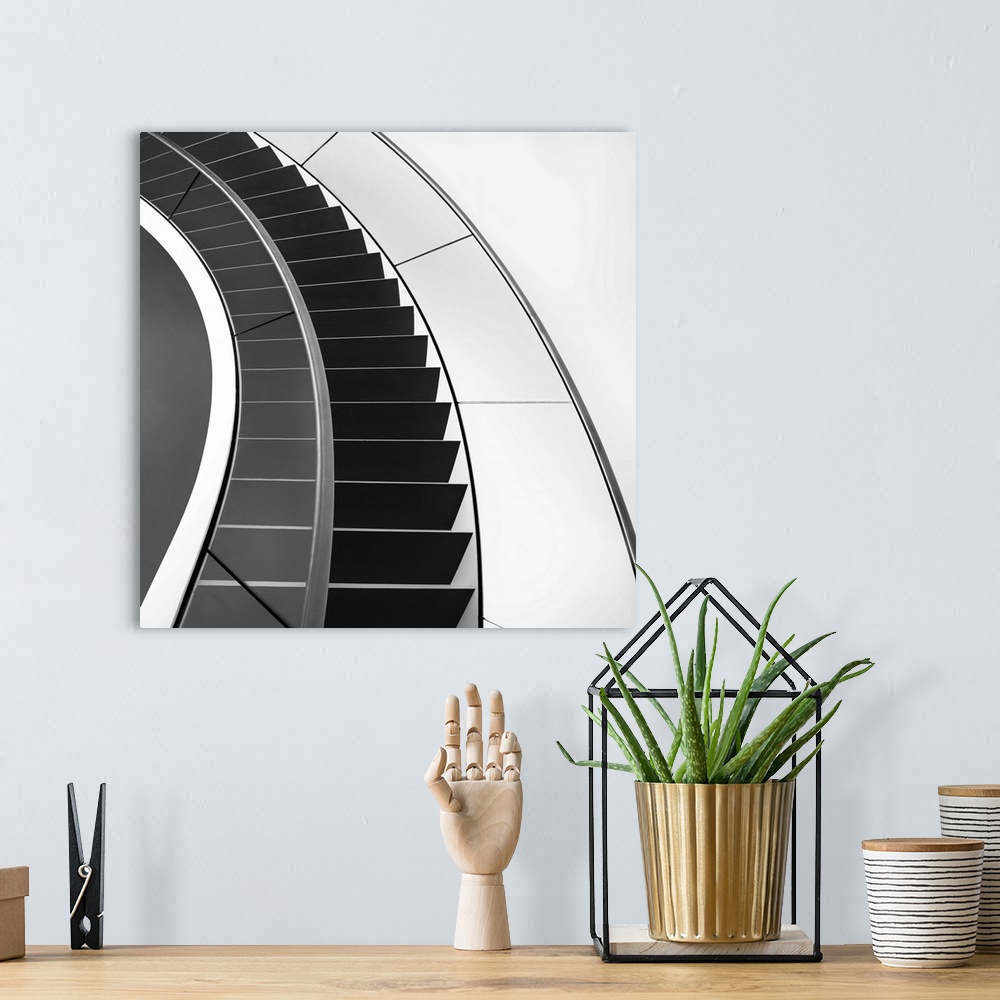 A bohemian room featuring Black and white image of a staircase curving around.
