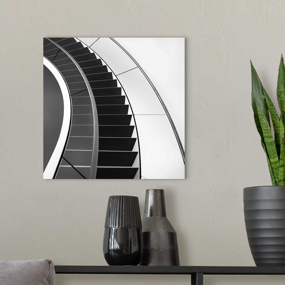 A modern room featuring Black and white image of a staircase curving around.