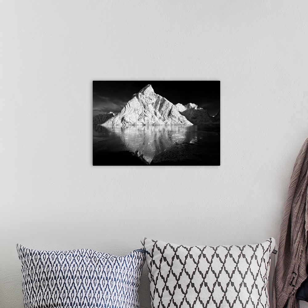 A bohemian room featuring Black and white image of a large white mountain rising from the ocean.