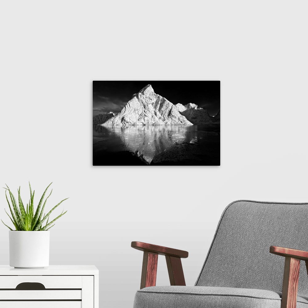 A modern room featuring Black and white image of a large white mountain rising from the ocean.