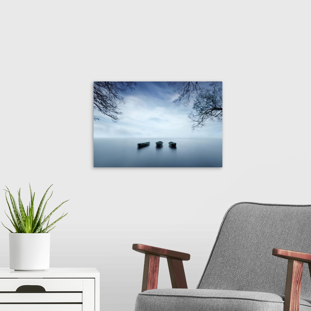 A modern room featuring Still seascape with three boats sitting silently.