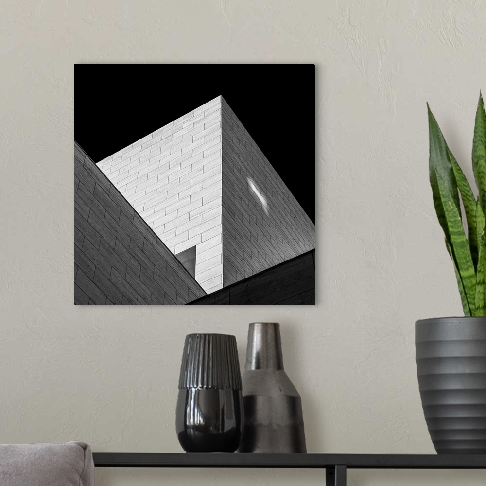 A modern room featuring Black and white image of triangular shadows created by a modern building.