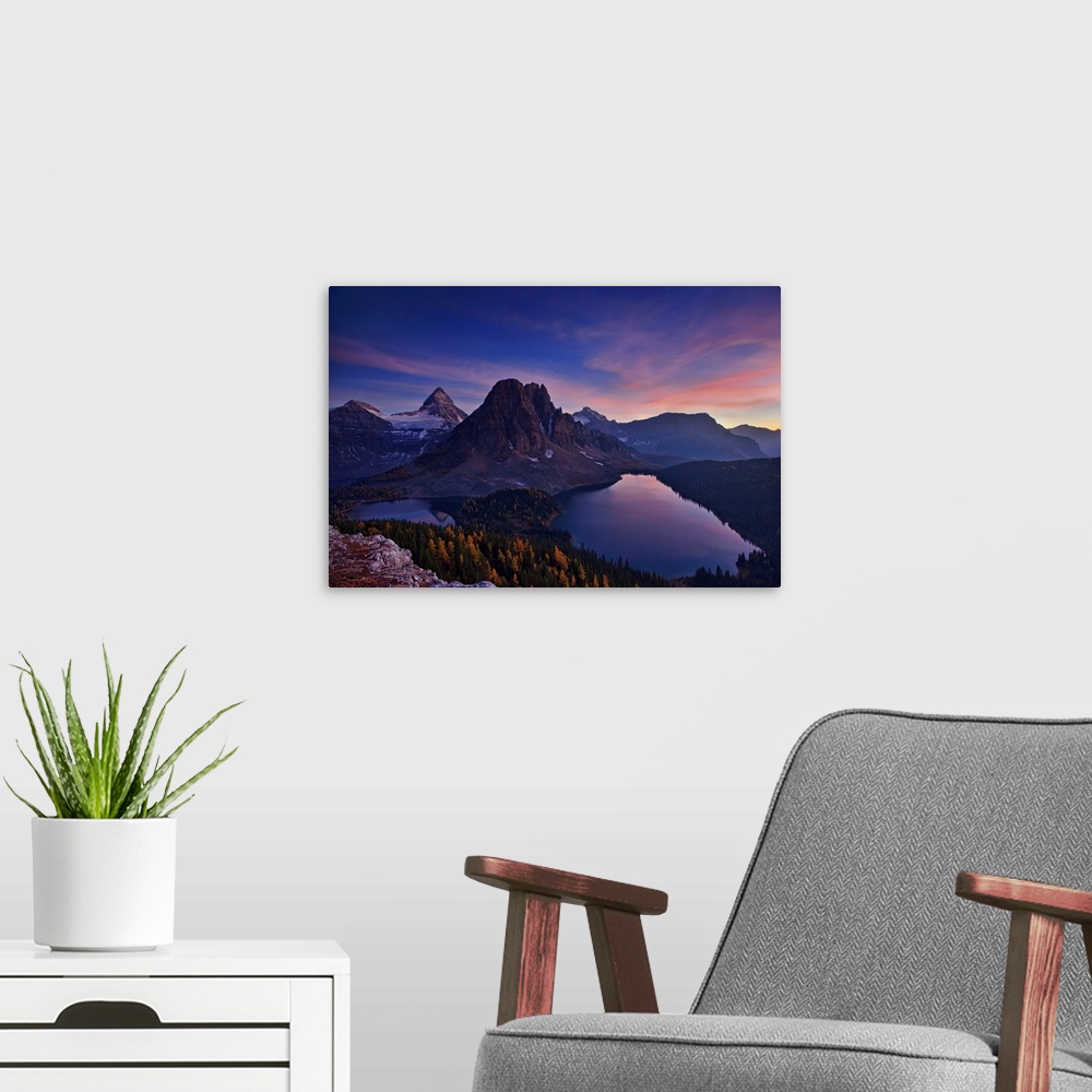 A modern room featuring View of two lakes and a snowy mountain range at sunset, with a pastel sky.