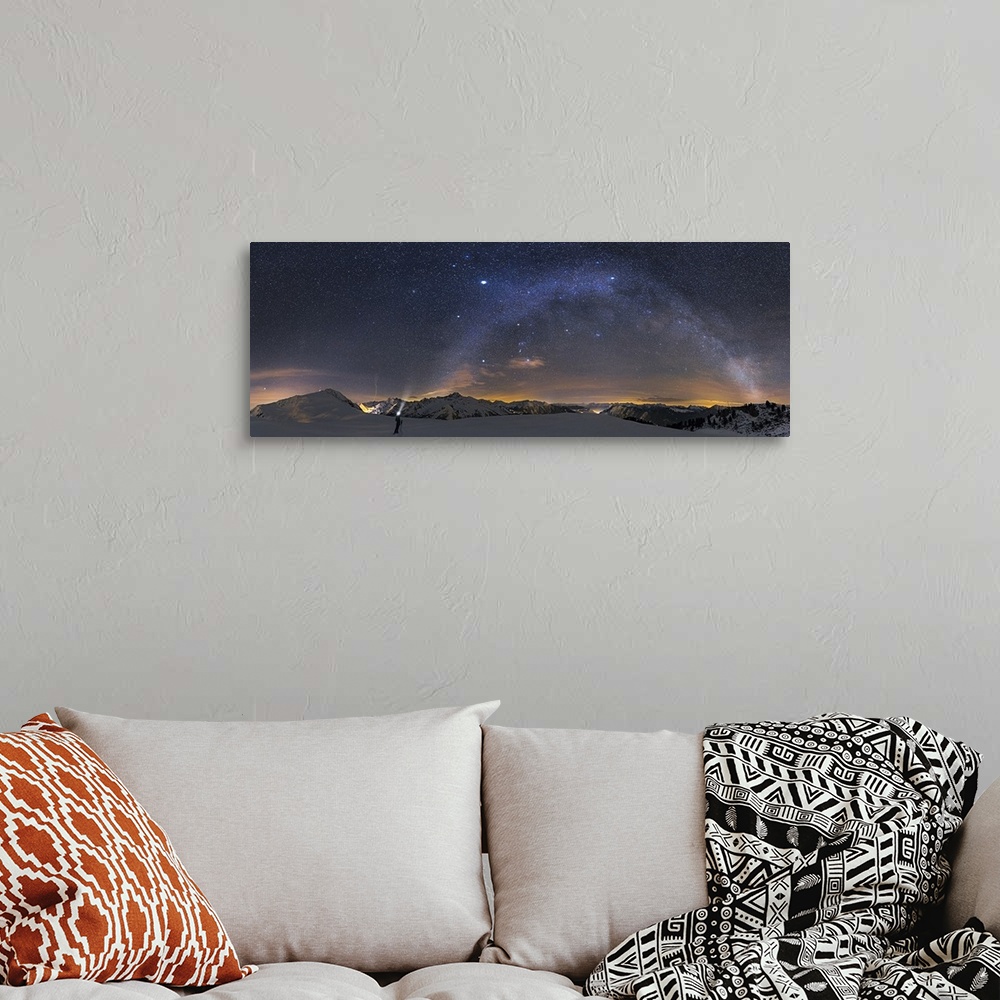 A bohemian room featuring A panoramic photograph of a person standing in a desolate mountainous snowscape under a starry ni...