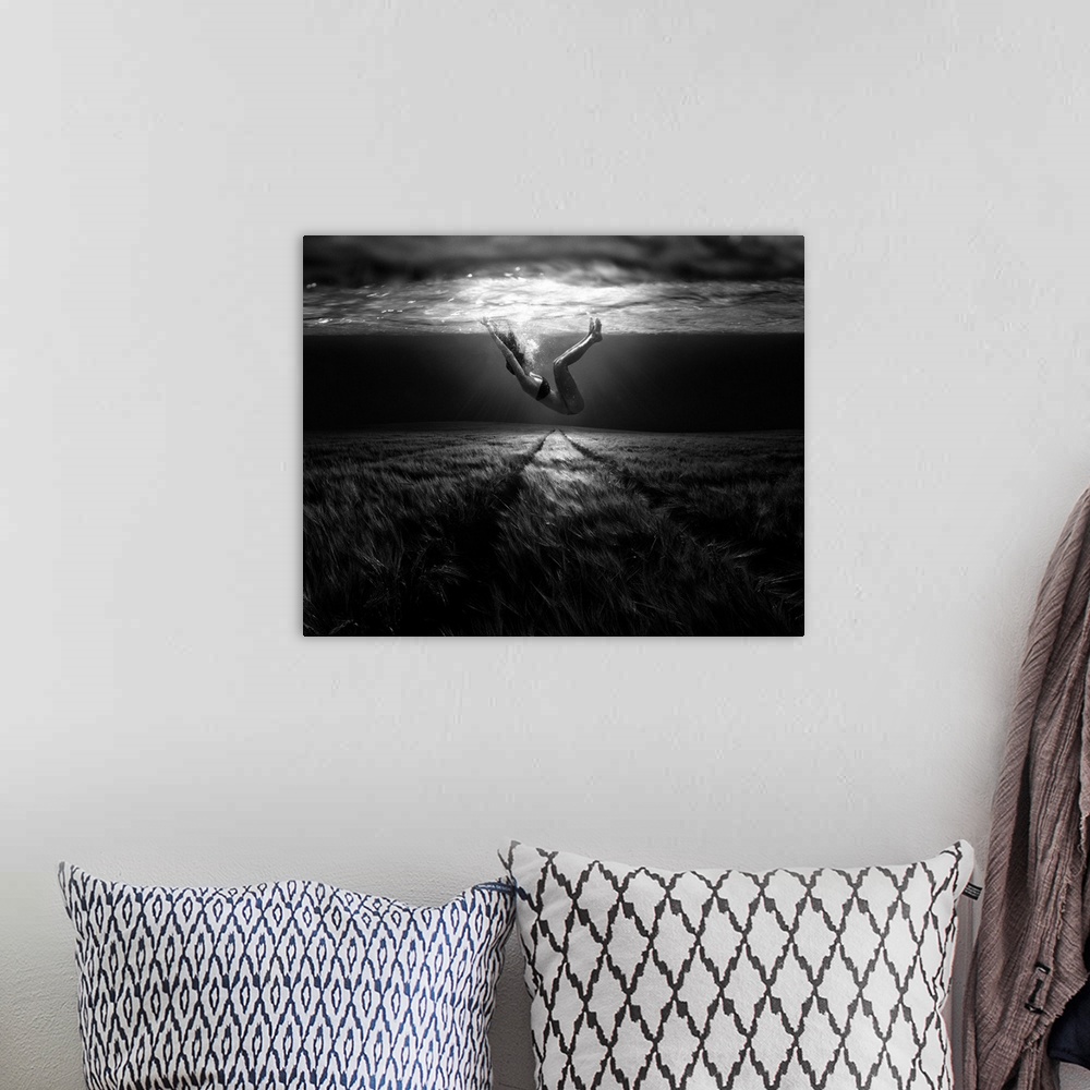 A bohemian room featuring A conceptual photograph of a woman floating under water above a grassy looking field.