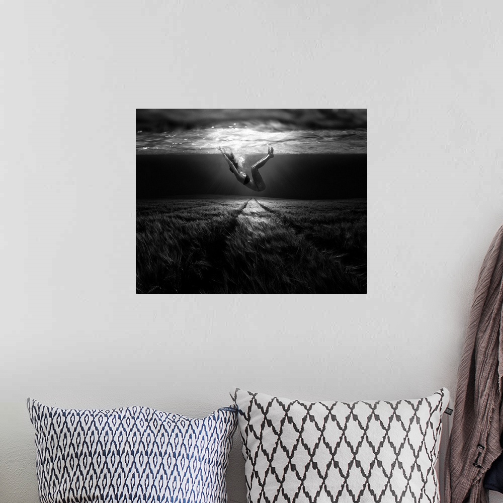 A bohemian room featuring A conceptual photograph of a woman floating under water above a grassy looking field.
