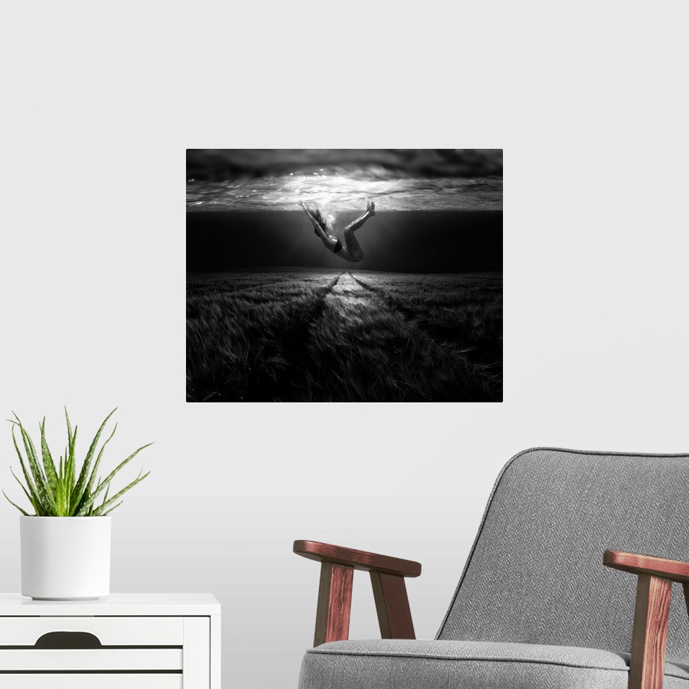 A modern room featuring A conceptual photograph of a woman floating under water above a grassy looking field.