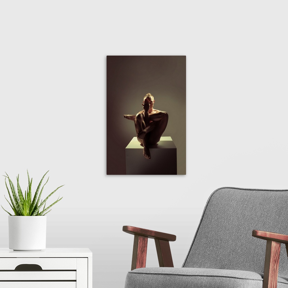 A modern room featuring Fine art portrait of a woman sitting on a platform creating angles with her body with dramatic li...