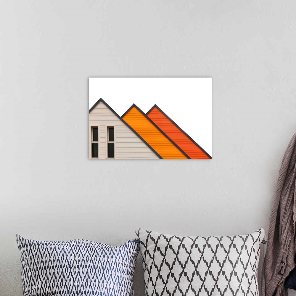A bohemian room featuring Architectural abstract photograph of three a-frame structures in white and shades of orange.