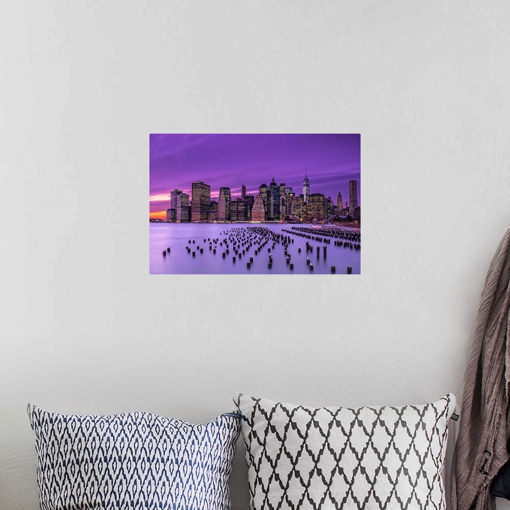 A bohemian room featuring Manhattan skyline at sunset under a purple sky, seen from Brooklyn.
