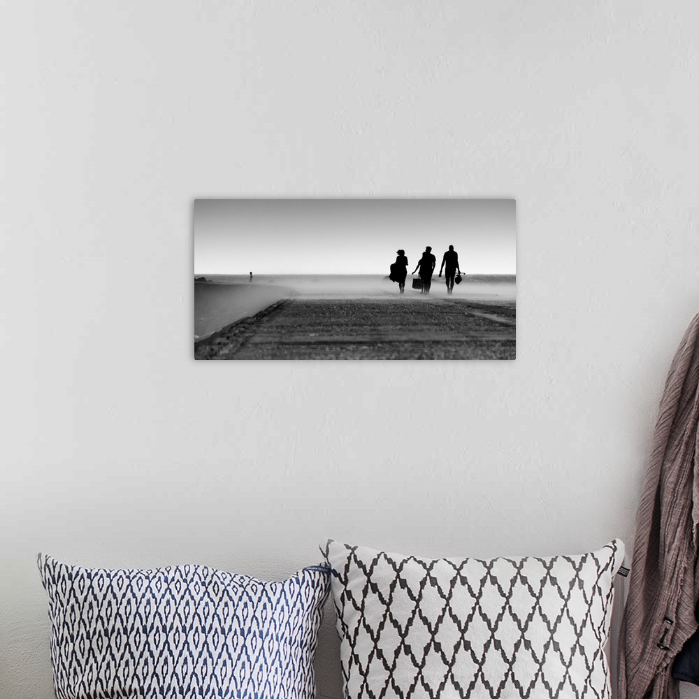 A bohemian room featuring A black and white photograph of three silhouetted figures walking toward a mist.