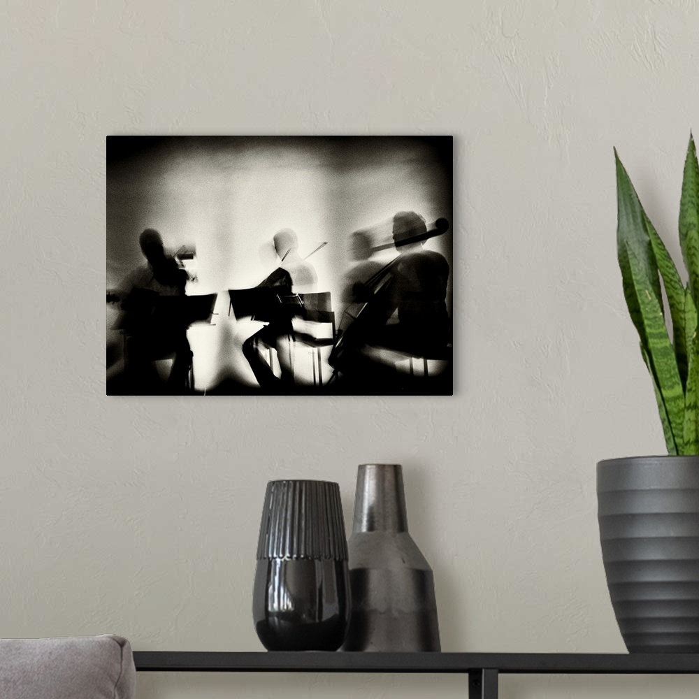 A modern room featuring Motion blur image of a string quartet playing.
