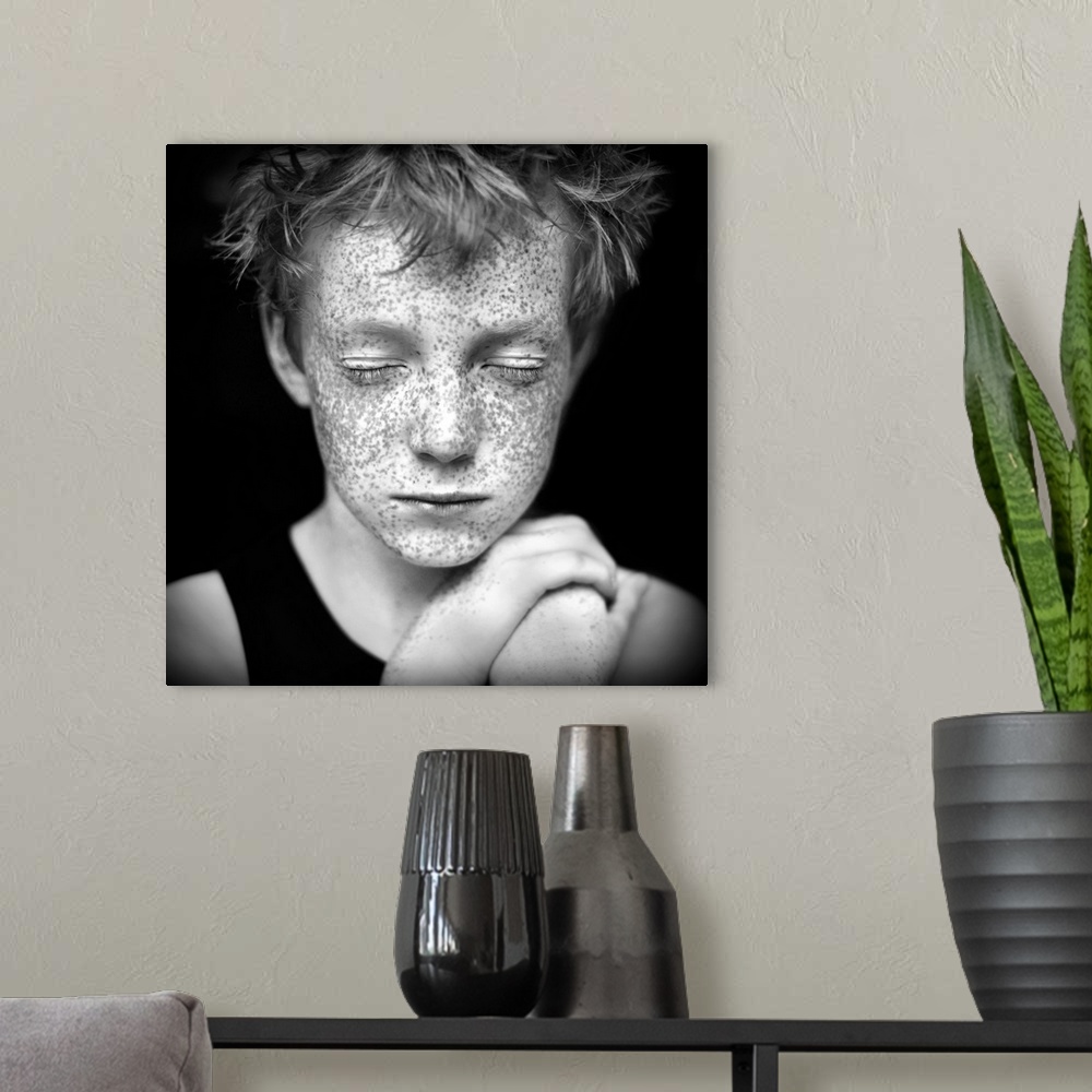 A modern room featuring Black and white portrait of a young boy with freckles.