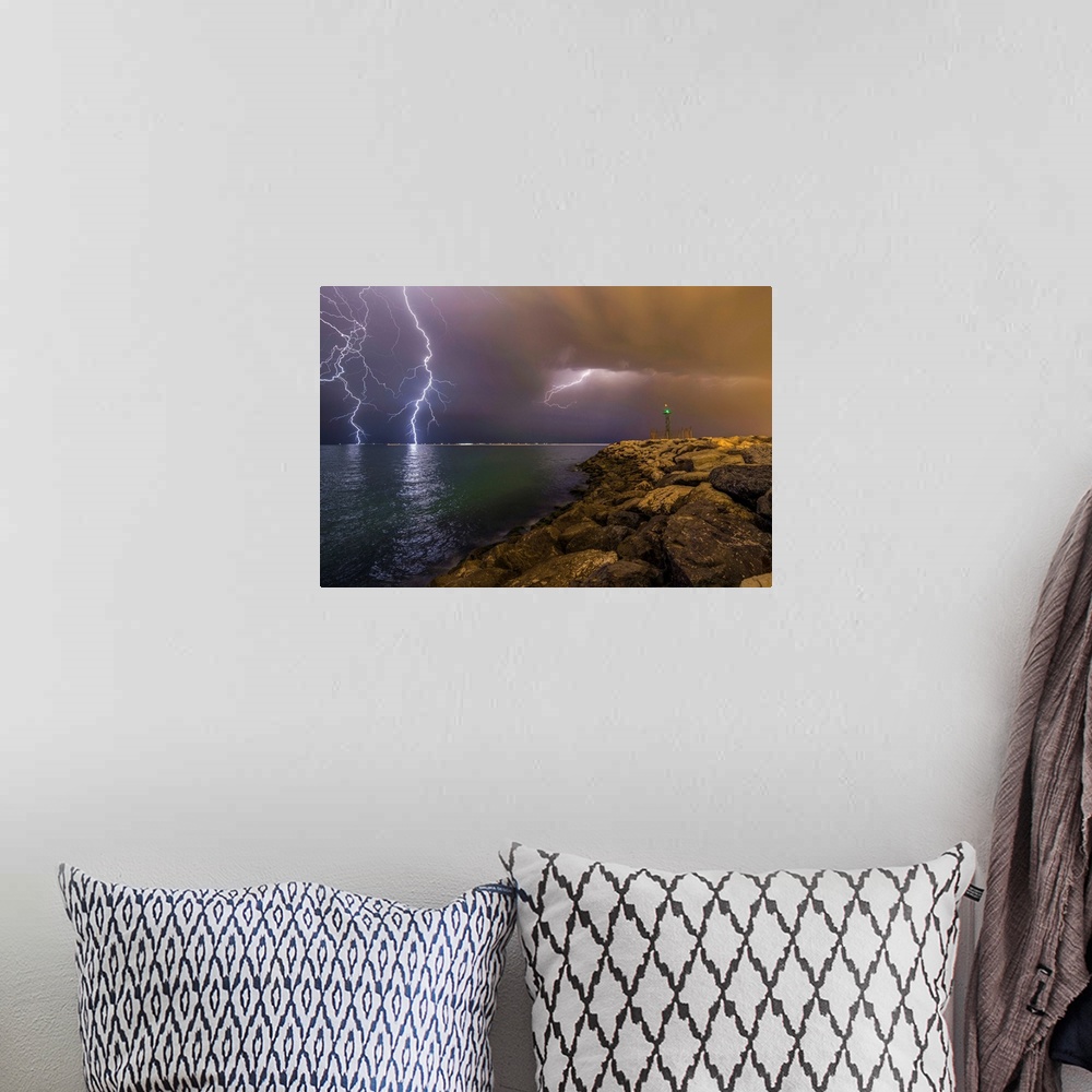 A bohemian room featuring An intense photograph of a coastal scene with multiple lightning strikes hitting the ocean.