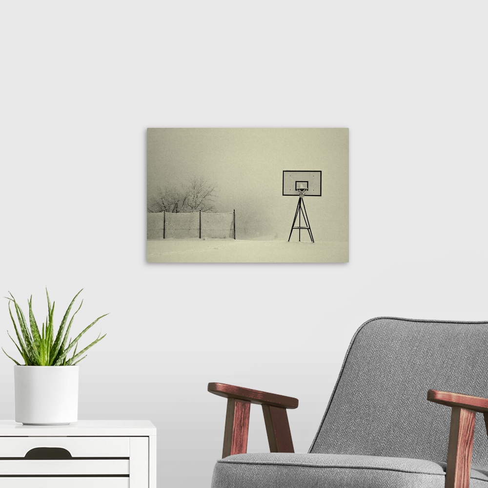 A modern room featuring A basketball hoop and chainlink fence with a layer of snow.