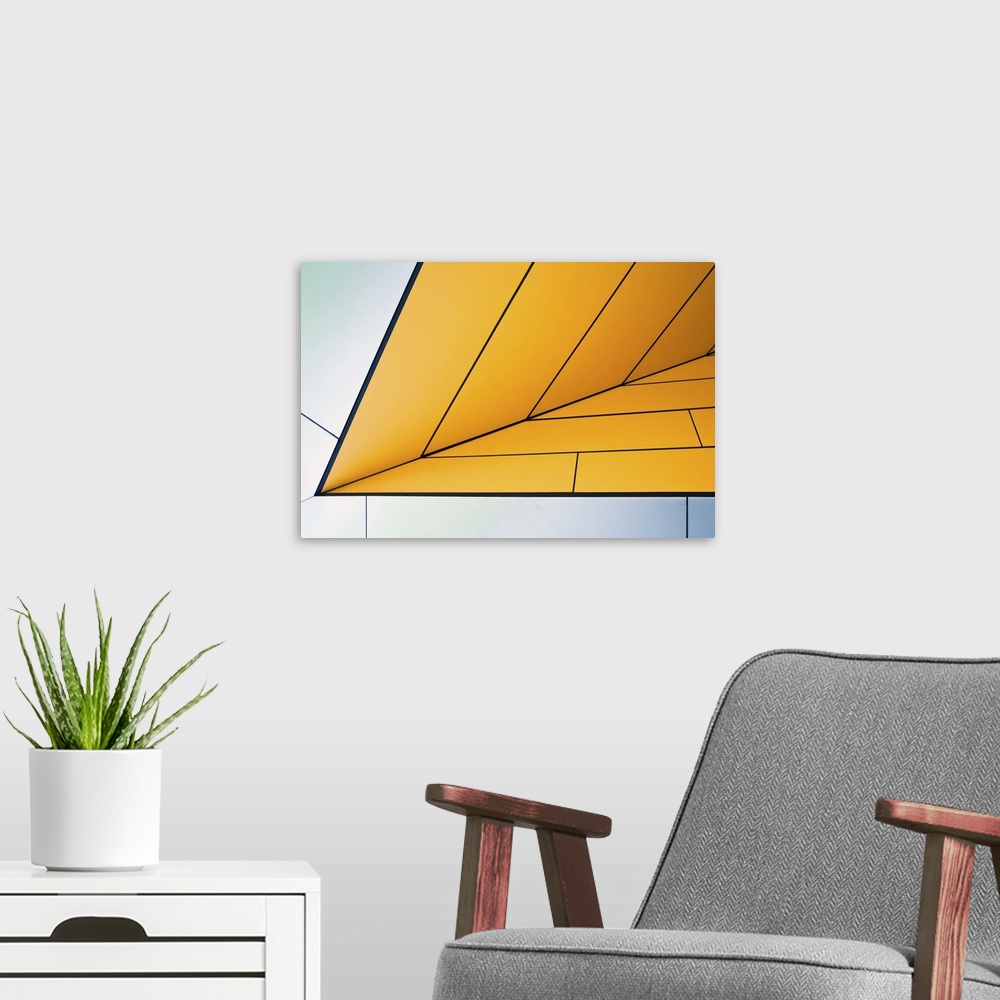 A modern room featuring Yellow and white panels on an angular wall creating an abstract image.