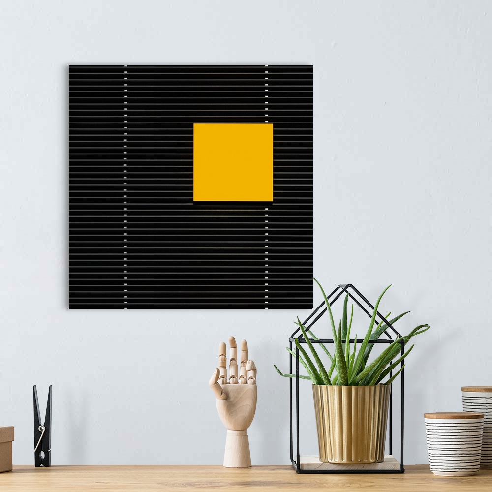 A bohemian room featuring A yellow square panel standing out against the horizontal lines of a building.