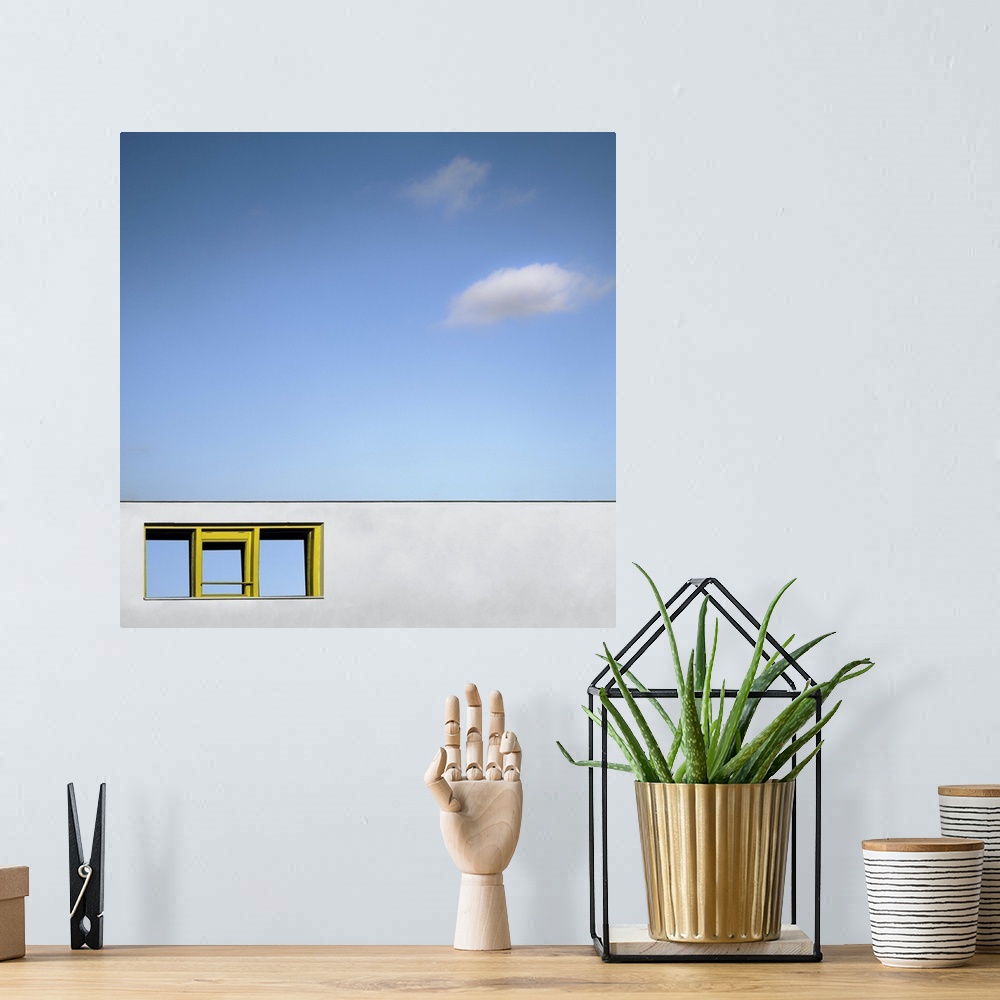 A bohemian room featuring Abstract view of a yellow framed window on a blank white wall facade, under a blue almost cloudle...