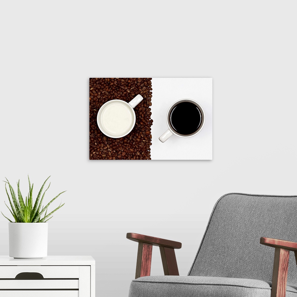 A modern room featuring Two mugs, one on a blank surface and the other on coffee beans.
