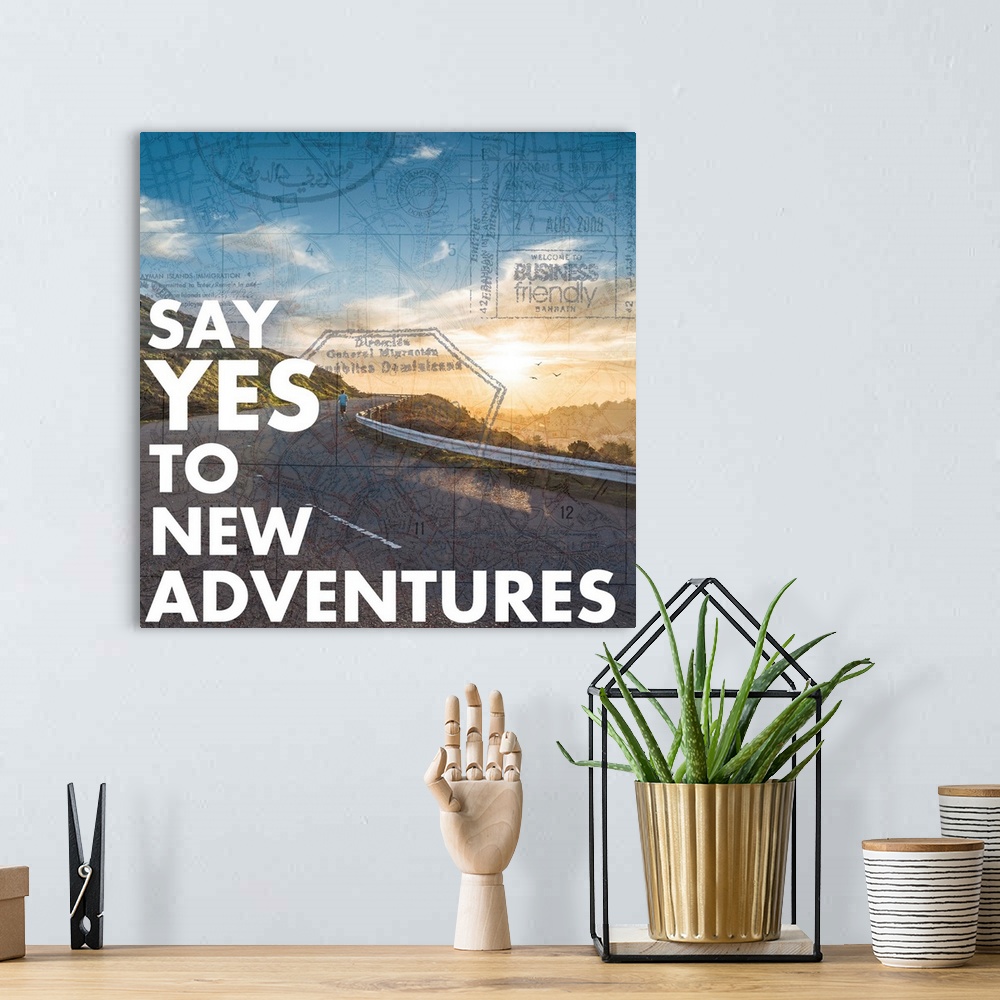 A bohemian room featuring "Say Yes to New Adventures" written on a photograph of a winding mountain road with the sun risin...