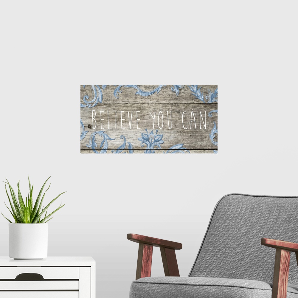 A modern room featuring "Believe you can" in thin letters on a wooden plank with blue florals.