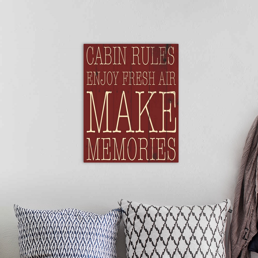 A bohemian room featuring Typographical artwork with "Cabin Rules" in a thin rustic text.