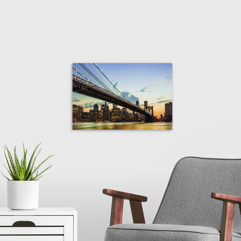 A modern room featuring Photograph of the Brooklyn Bridge spanning the East River, in the soft glow of sunset.