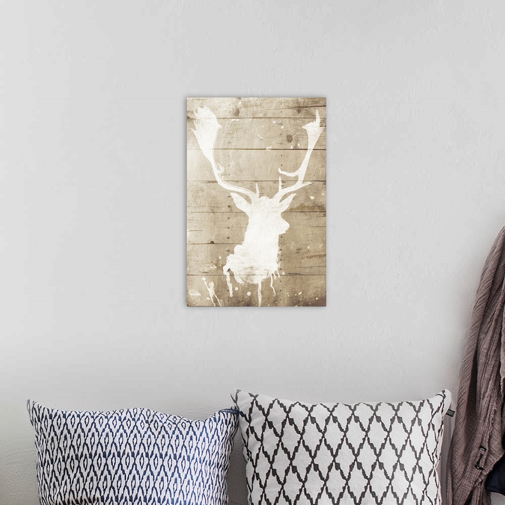 A bohemian room featuring A white silhouette of a deer painted on a wood background with some paint drips and splatter.