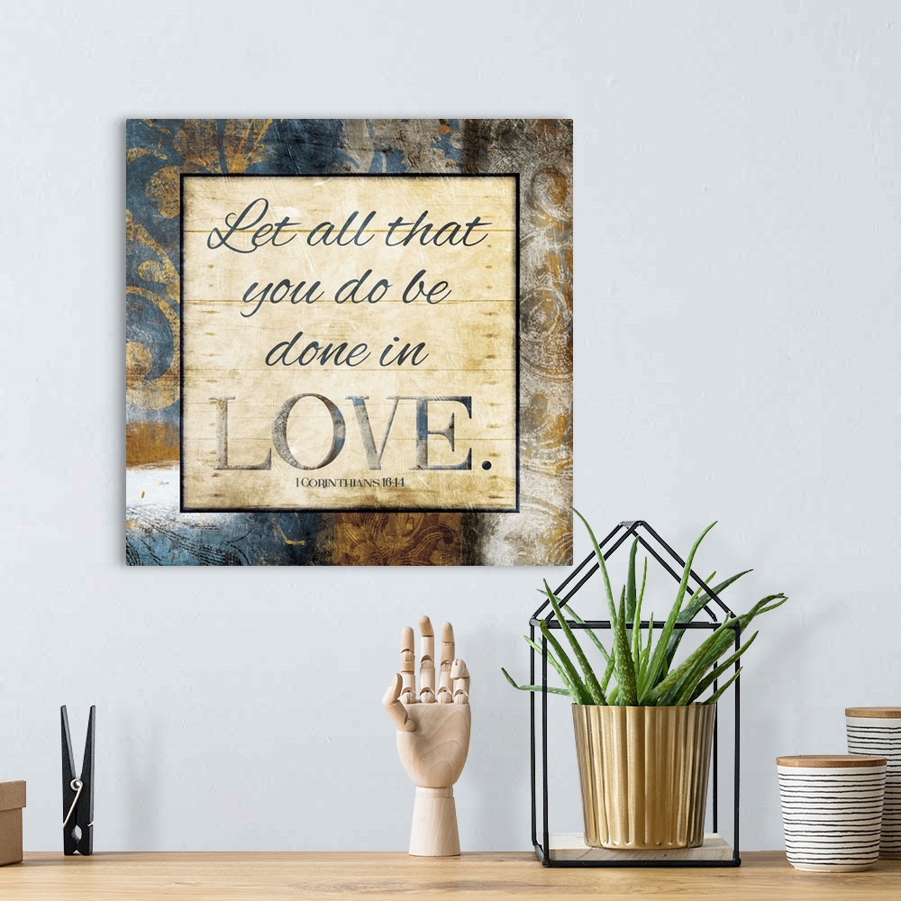 A bohemian room featuring Typography art of the Bible verse 1 Corinthians 16:14 framed with classic style gold and blue flo...