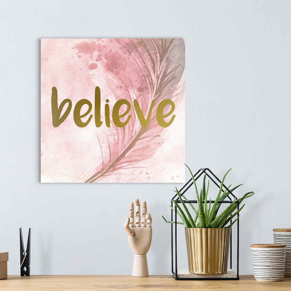 A bohemian room featuring A pink watercolor painting of a feather with the word ?believe? placed on top in gold text.�