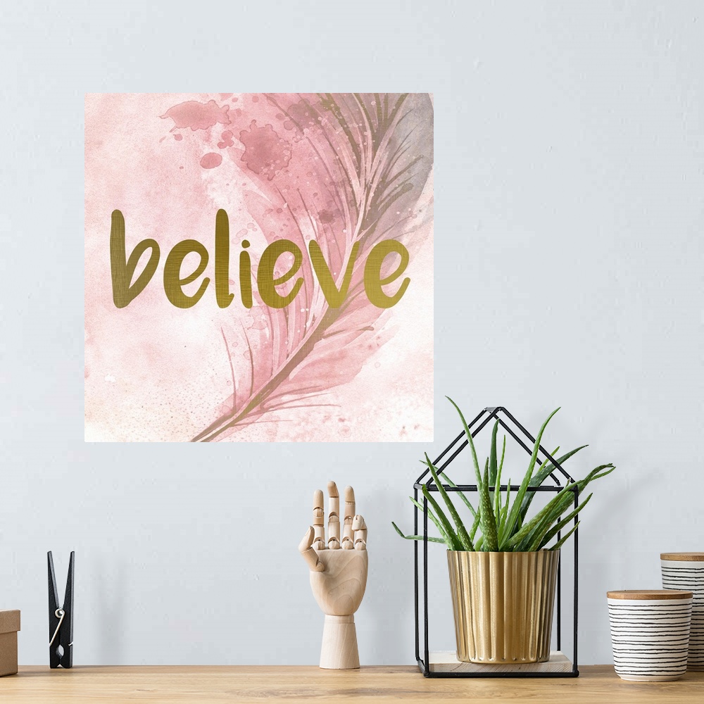 A bohemian room featuring A pink watercolor painting of a feather with the word ?believe? placed on top in gold text.�