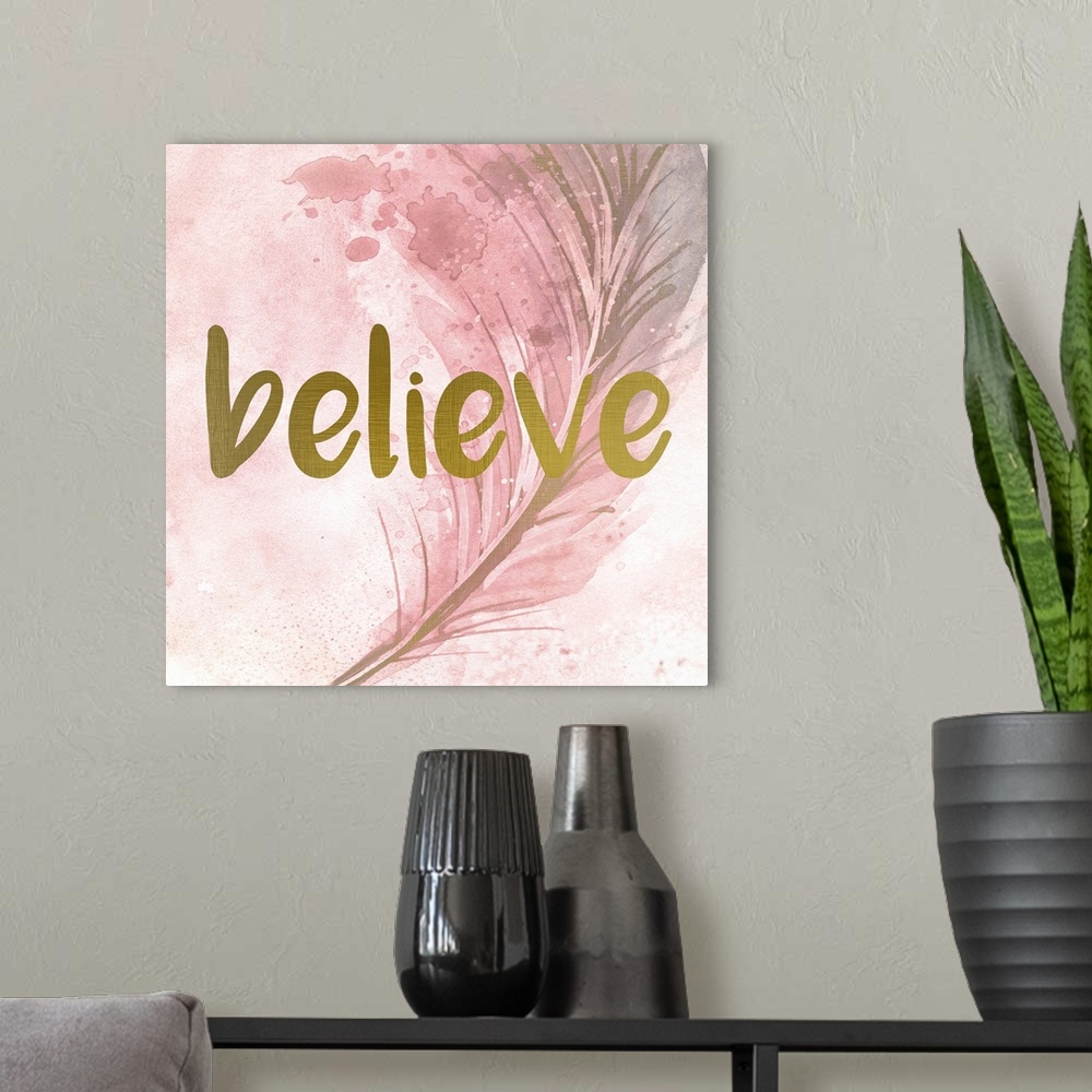 A modern room featuring A pink watercolor painting of a feather with the word ?believe? placed on top in gold text.�