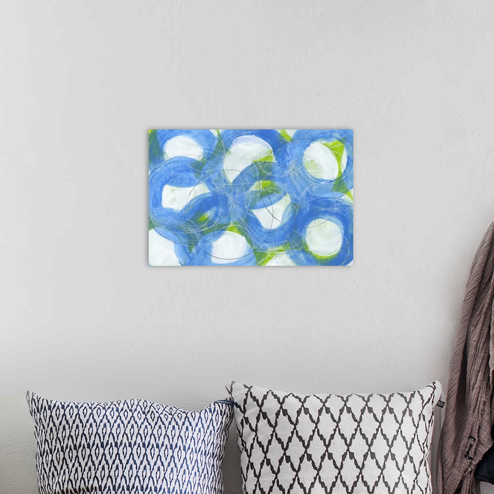 A bohemian room featuring Contemporary abstract artwork made of several large rings in blue tones.